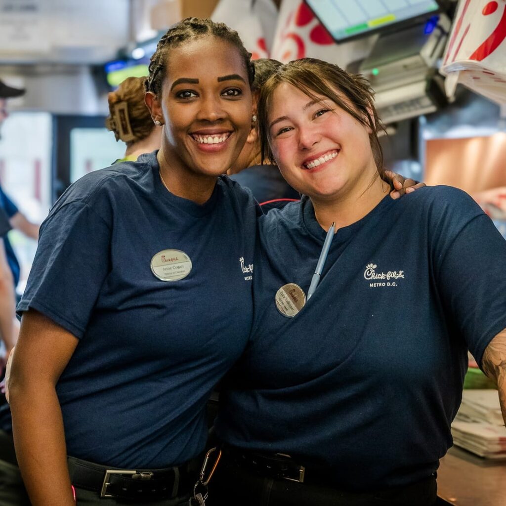 Two chick-fil-a workers posing for a photo